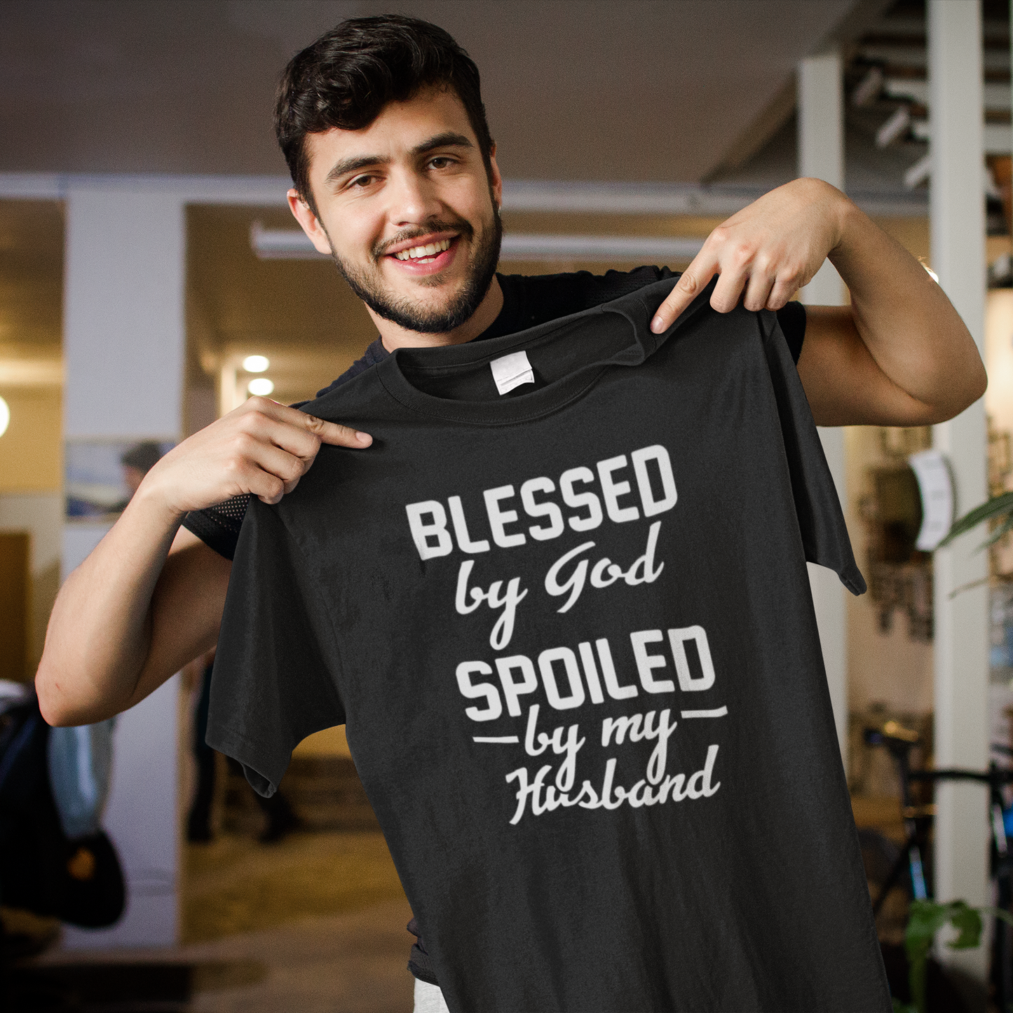 Black heavyweight garment-dyed cotton tee with "Blessed by God, Spoiled by My Husband" text design, made from 100% USA cotton.