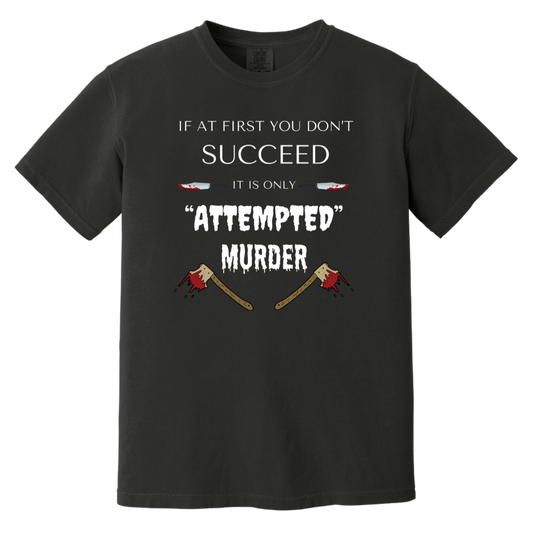 Black heavyweight garment-dyed cotton t-shirt featuring humorous quote 'If at first you don't succeed, it is only attempted murder' with images of bloody knives and axes.